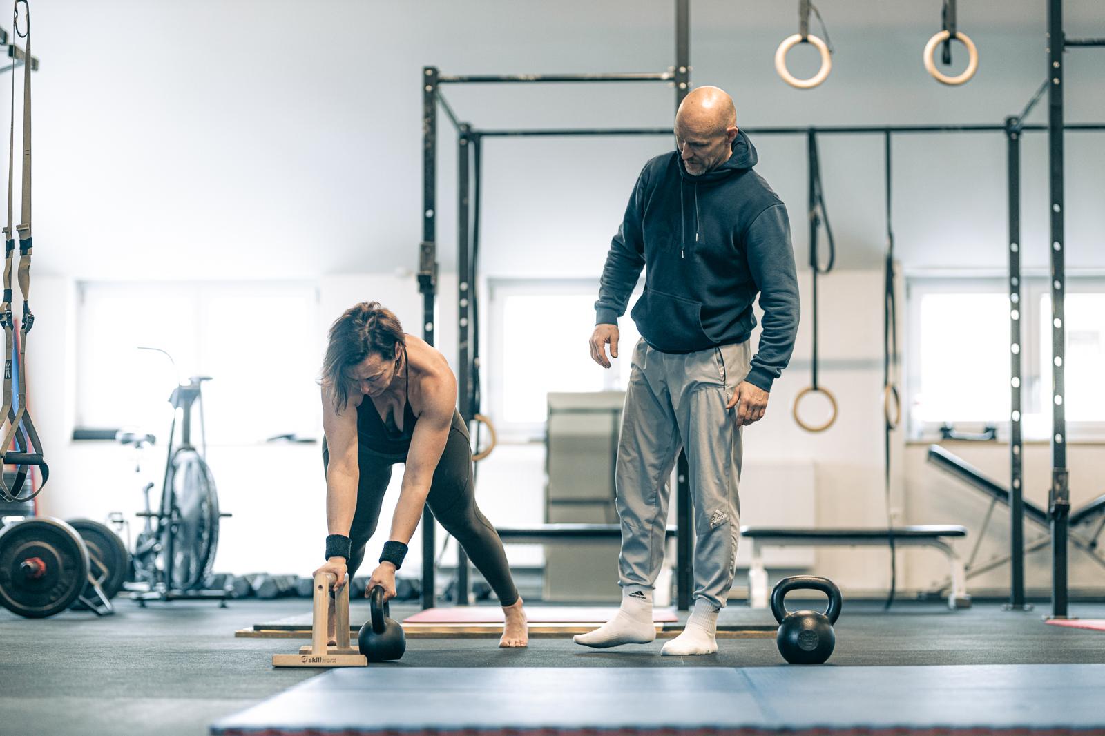 Personal Training – Sven Kresin betreut eine Athletin an den Parallettes